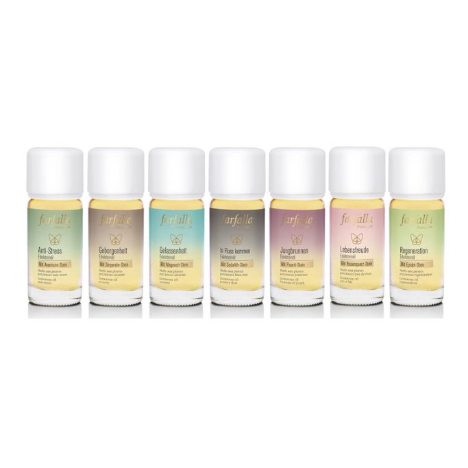 Set von acht Fläschchen mit unterschiedlichen flüssigen Inhaltsstoffen in sanften Farben.