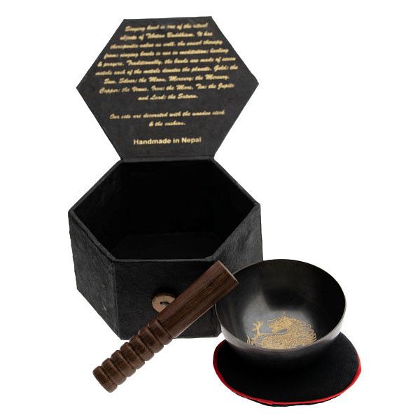Schwarze hexagonale Box mit Schüssel, Löffel und goldfarbener Deko.