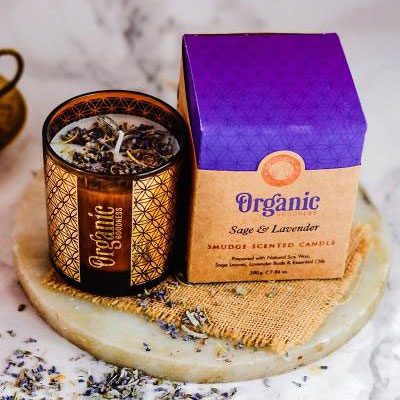 Kräuterkerze mit Lavendel in braunem Glasbehälter und lila Verpackung.